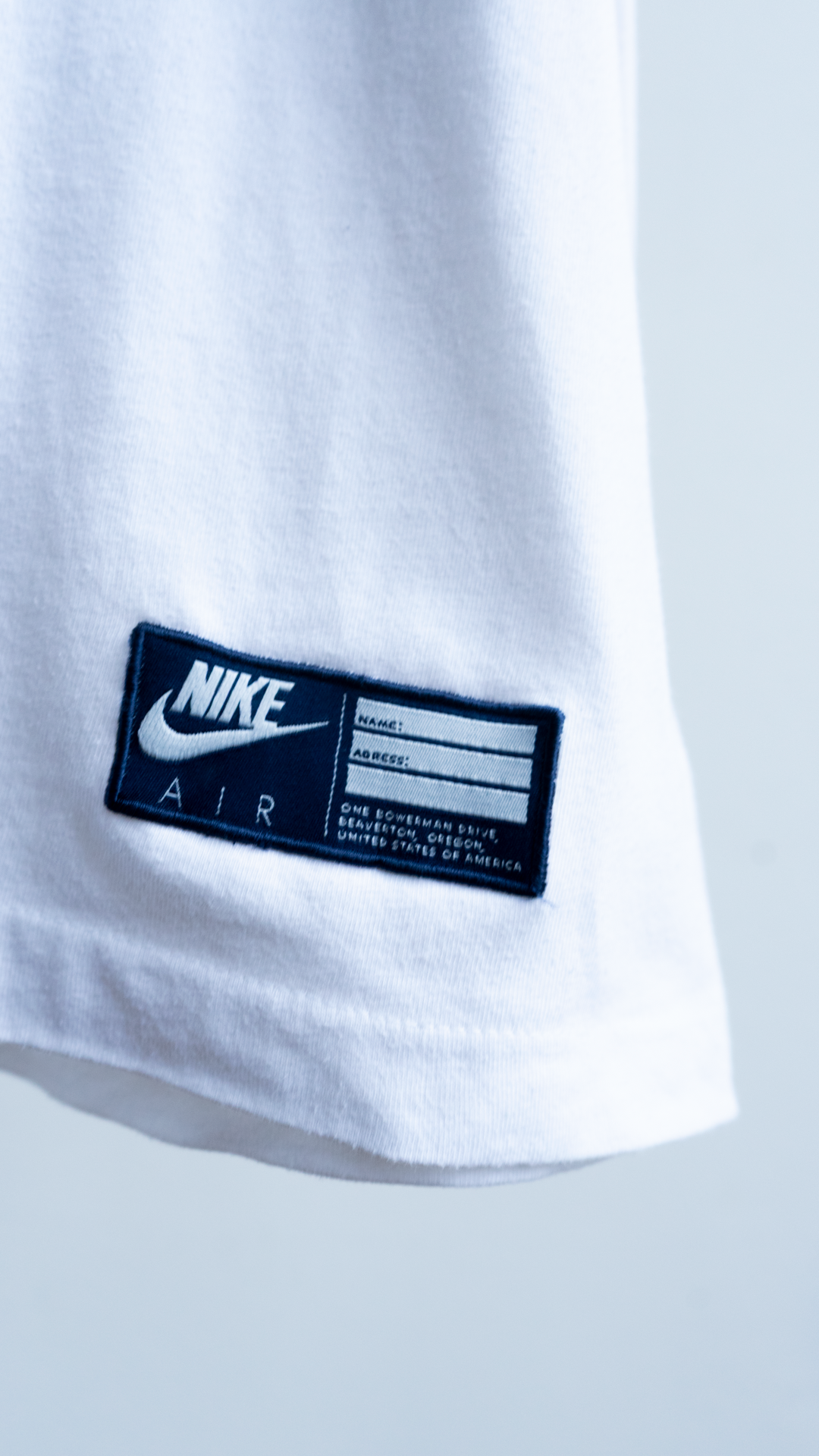 Close-up of a Nike Air label on a white blue red 80s shirt