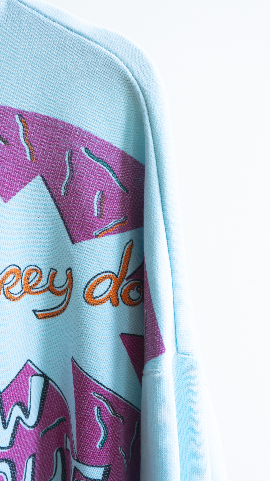 detail light blue secondhand 80s sweater with comic graphics