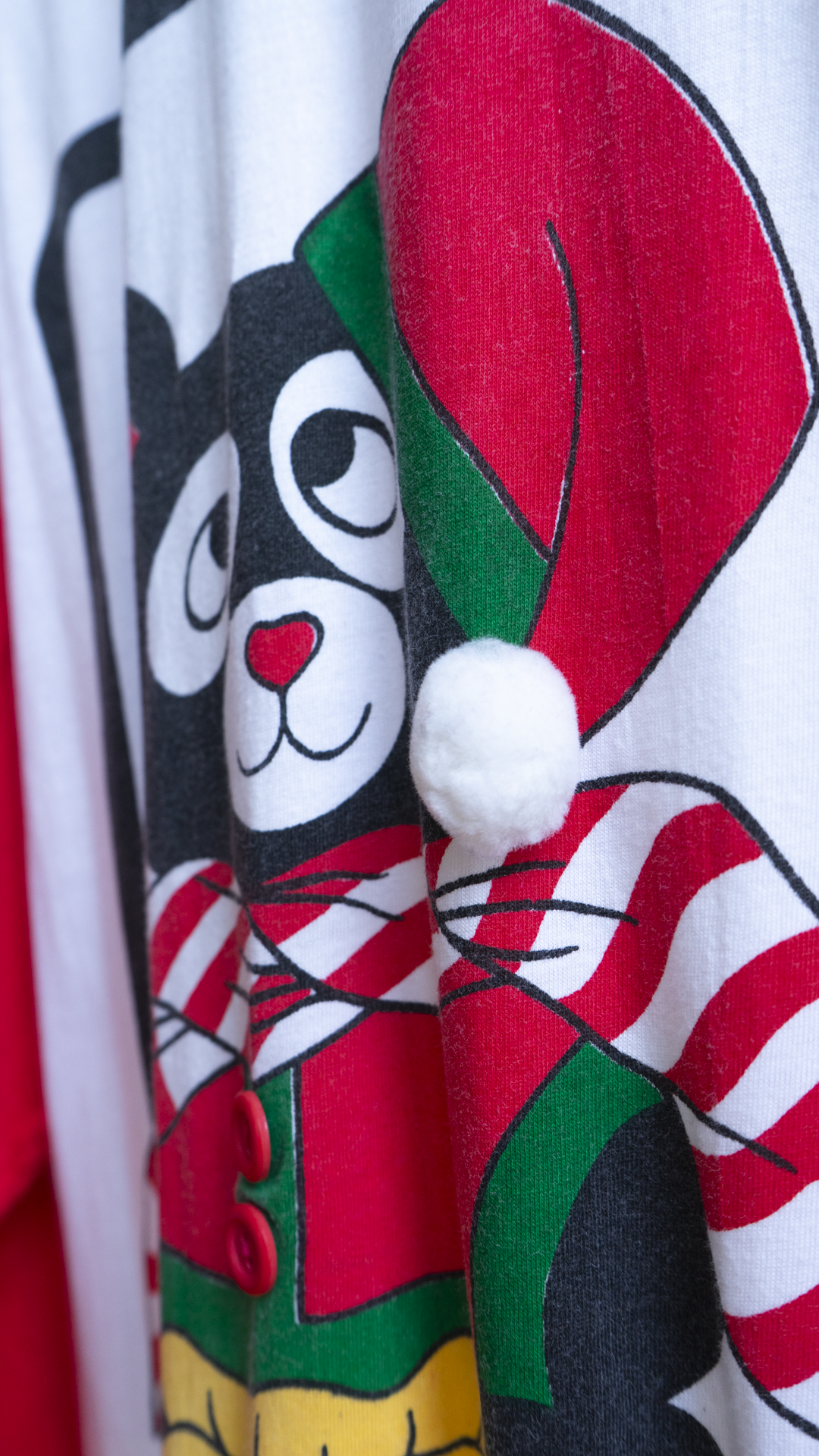 detail of a 80s christmas nightshirt with teddy bear wearing a santa hat with a 3D pom-pom.