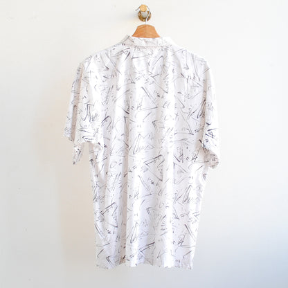 back of white vintage shirt with black pattern on a hanger in 80s or 90s style