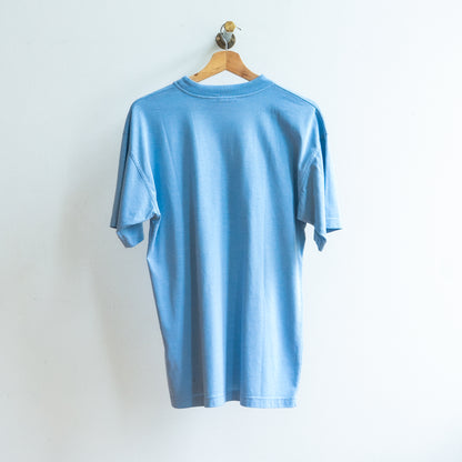 achterkant van lichtblauwe tweedehands tshirt op kapstok 