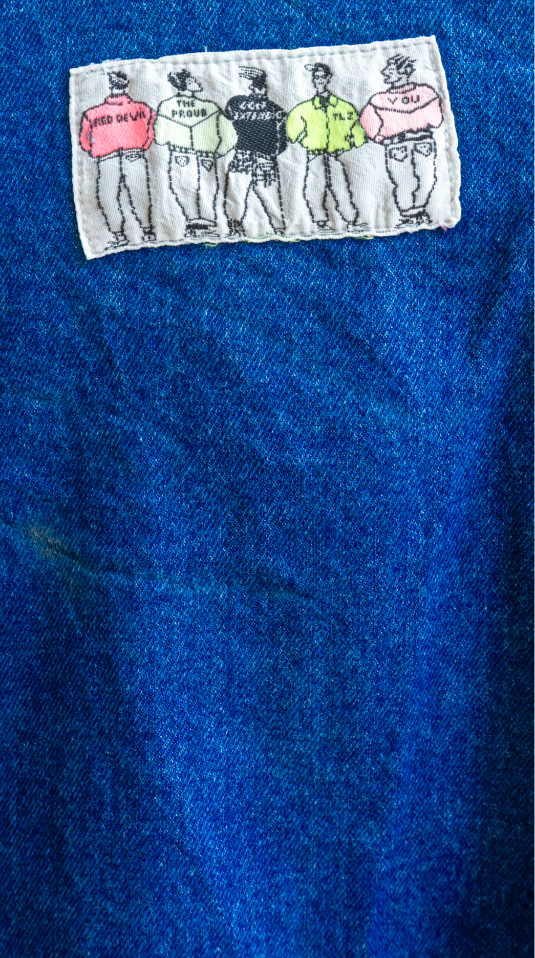 cropped dark blue denim jeans jacket with 90s label close-up of label demonstrating 5 men wearing baggy trousers and jeans jackets in different colors 