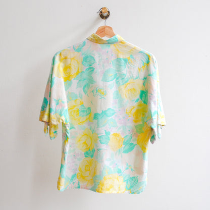 afbeelding-van-vintage-blouse-aan-kapstok-met-grote-gele-bloemen-in-combinatie-met-wit-en-groen