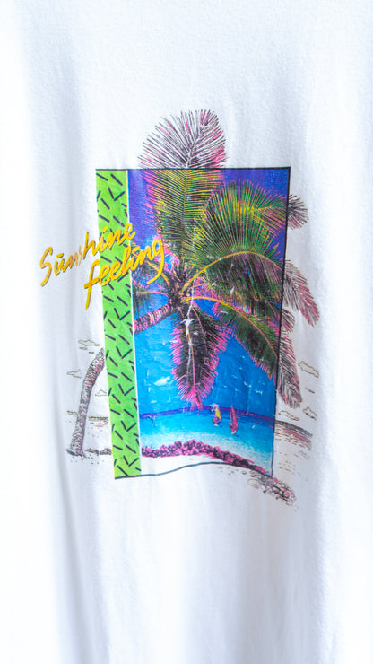 Grafische print met palmboom een zicht op de oceaan en tekst sunshine feeling in het geel op een witte vintage t-shirt