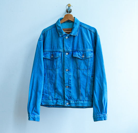 lichtblauwe tweedehands jeansjas met lange mouwen en knopen in het midden en twee borstzakken met knopen fresh vintage