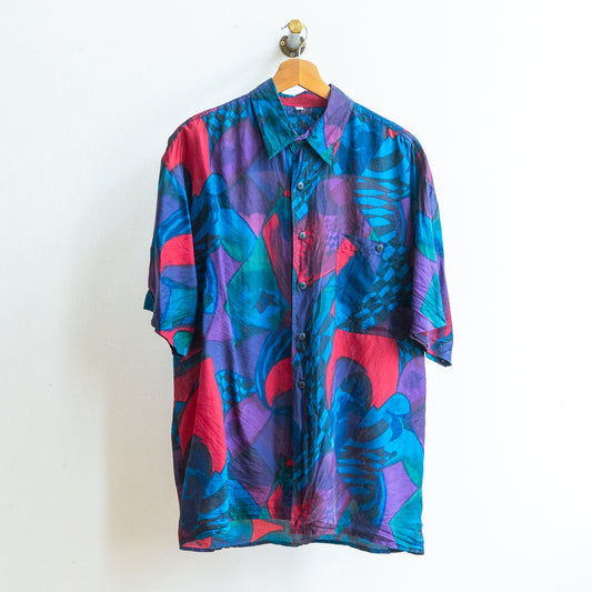 Colorful patterned vintage shirt in dark blue purple green red in a soft fabric on a hanger