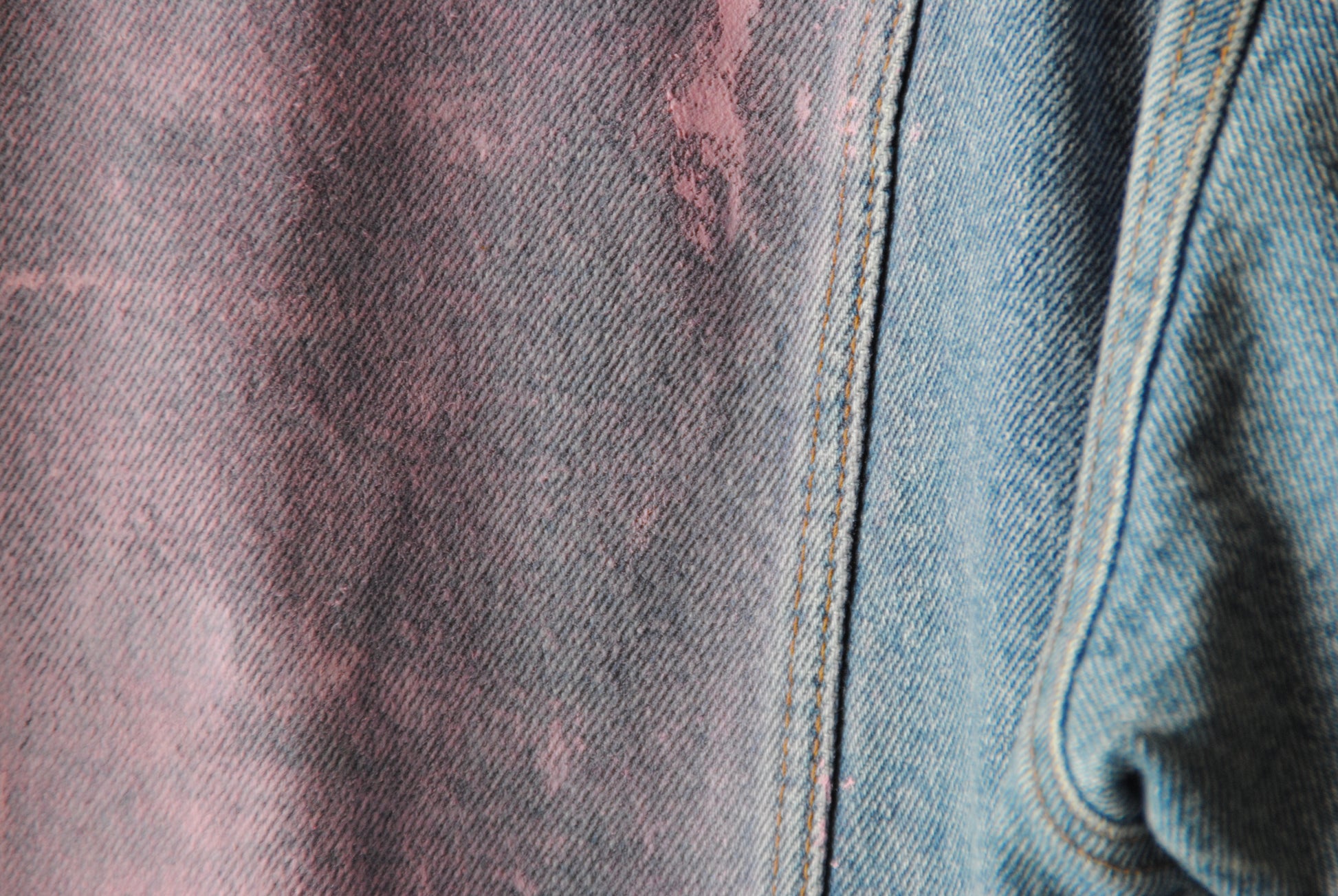 lichte vintage jeansjas met zachtroze verf ingezoomd