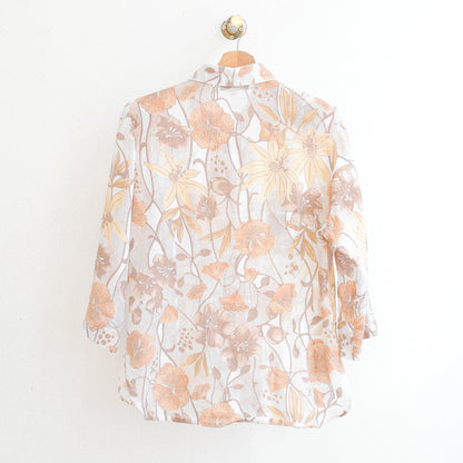 the back of a white vintage modissimo see-through vintage blouse with beige and orange flowers which is made in france