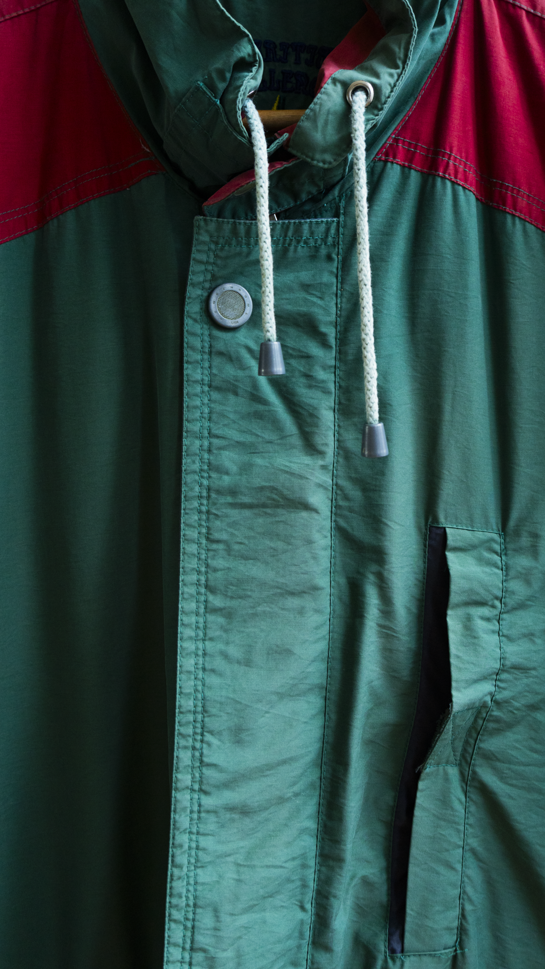 close-up of 80s raincoat green red drawstring and buttons