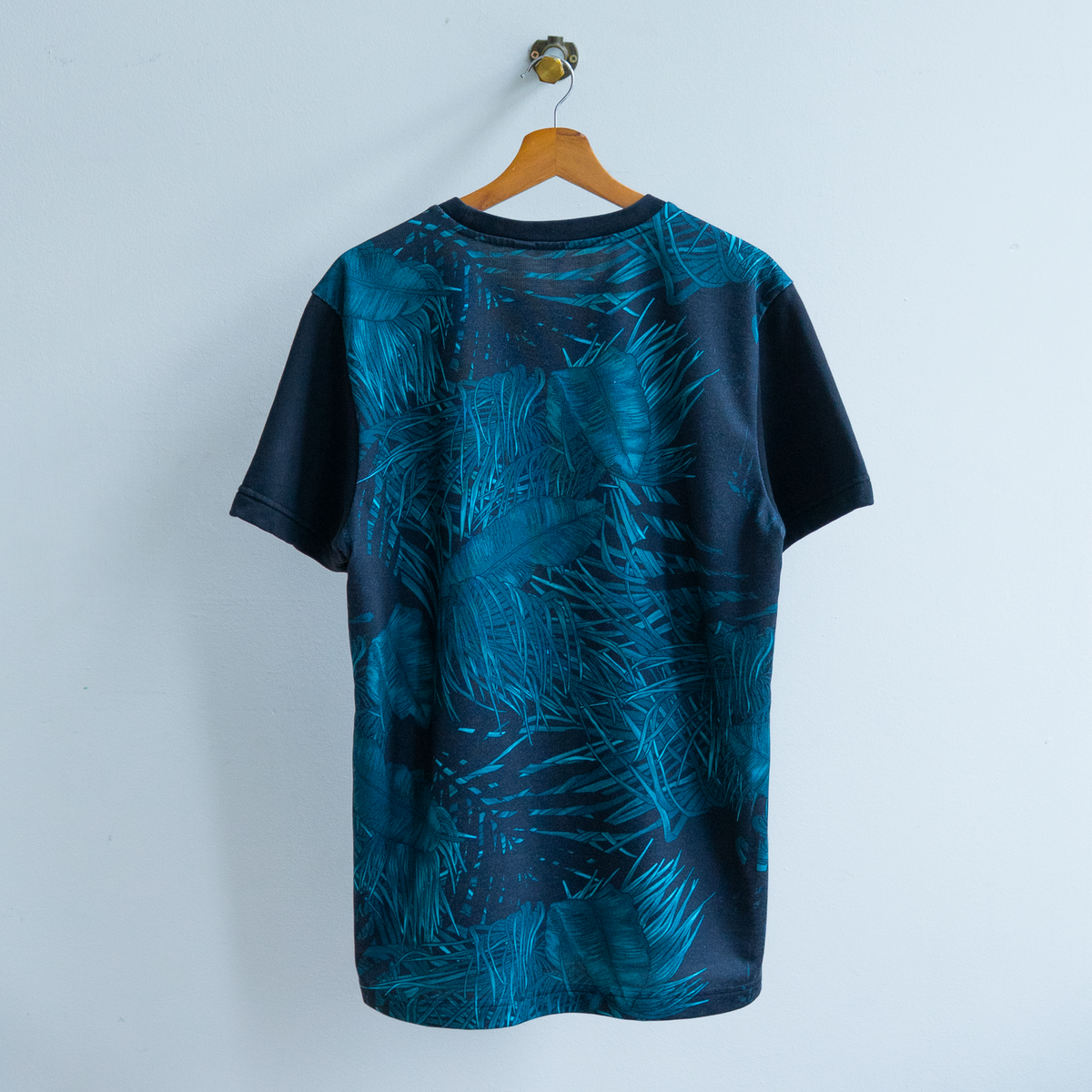 secondhand black adidas t-shirt with short sleeves and blue grass and leaves pattern on the back